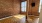 room with wood floors brick walls and windows