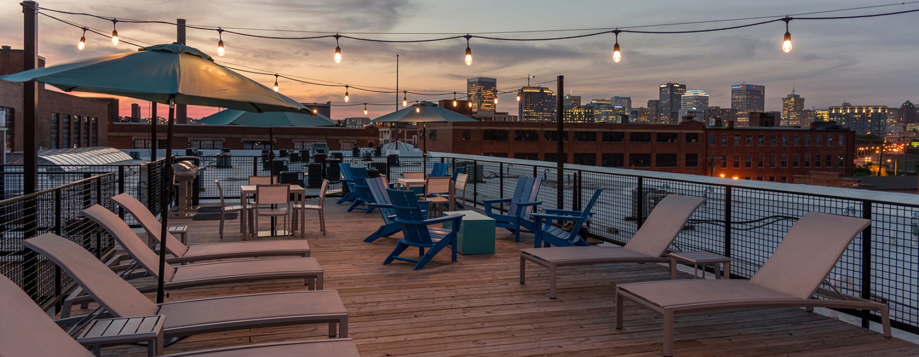 rooftop patio with seating lights and view of a city